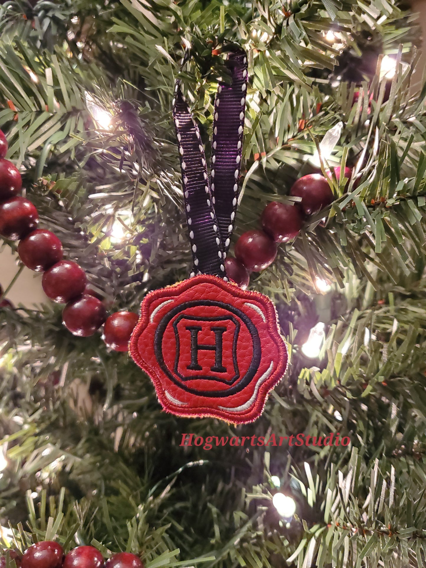 a black-stitched wax seal ornament on a tree