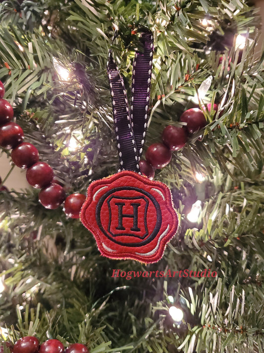 a black-stitched wax seal ornament on a tree